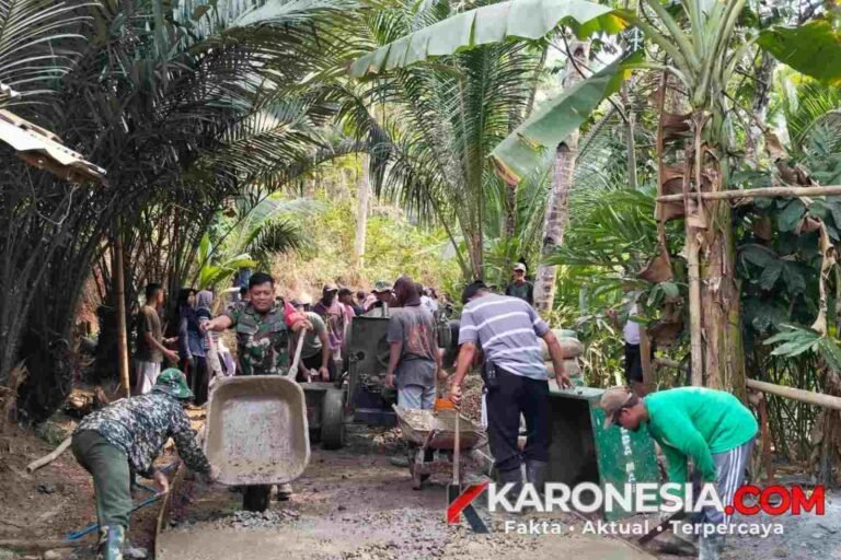 Prajurit TNI dan warga gotong royong melakukan pengecoran jalan beton di Kabupaten Banyumas.