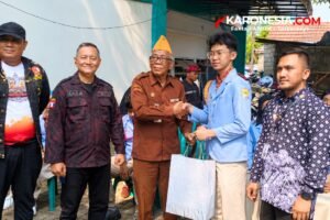 Veteran berseragam cokelat berjabat tangan dengan siswa OSIS berseragam biru muda saat penyerahan bingkisan di Markas DPC LVRI Tangerang Selatan
