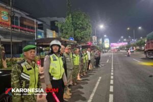 Prajurit TNI, polisi, dan Satpol PP berbaris saat apel patroli malam di jalan raya Kota Bekasi
