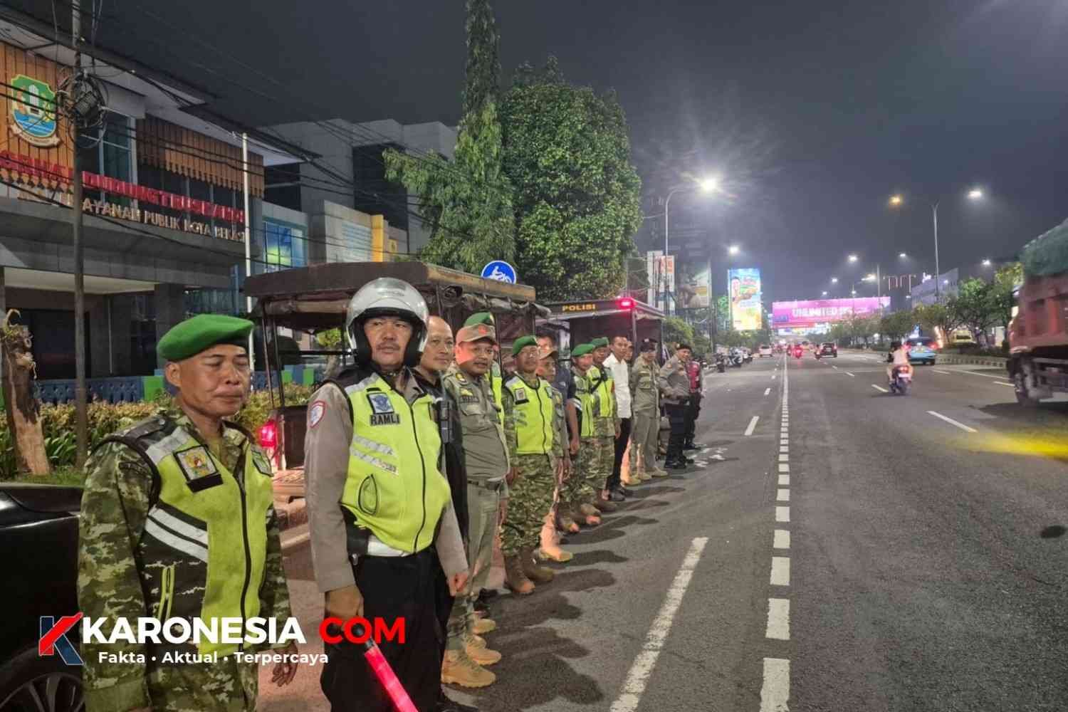 Prajurit TNI, polisi, dan Satpol PP berbaris saat apel patroli malam di jalan raya Kota Bekasi