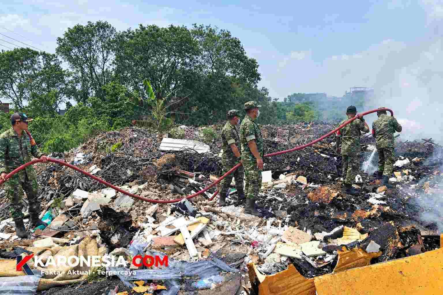 Personel Koramil 03/Legok menyemprotkan air dengan selang saat memadamkan kebakaran tumpukan sampah di Pagedangan, Tangerang