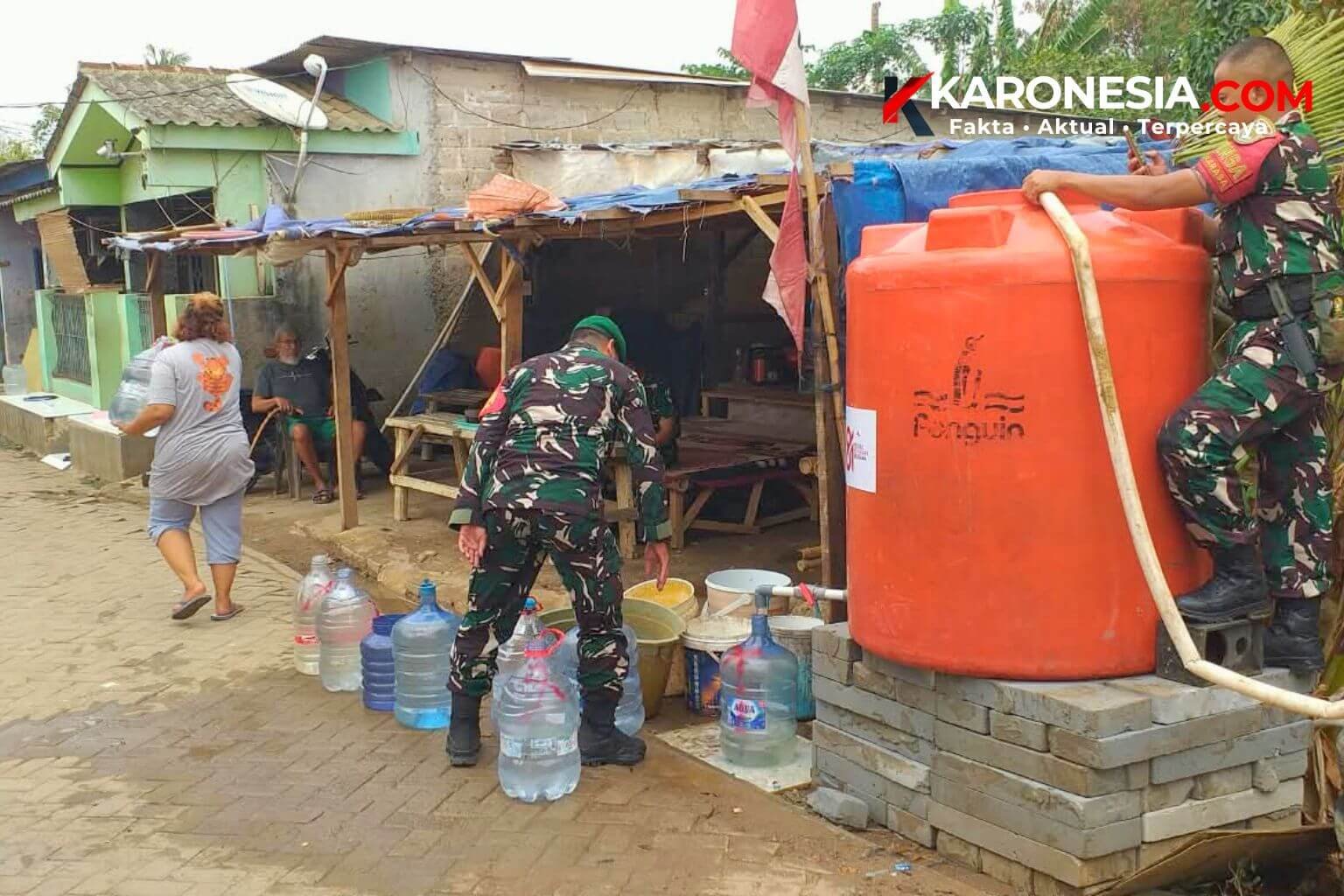Personel Koramil 01 Tangerang mengisi tandon dan galon air warga saat penyaluran bantuan air bersih PDAM di Kunciran Jaya.