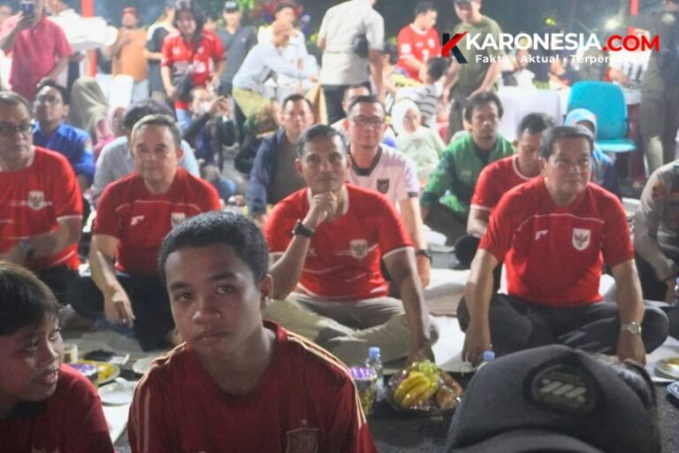 Warga dan jajaran pejabat berkaus merah timnas duduk lesehan menyaksikan nobar final FIFA ASEAN Cup 2026 di Tigaraksa, Kabupaten Tangerang
