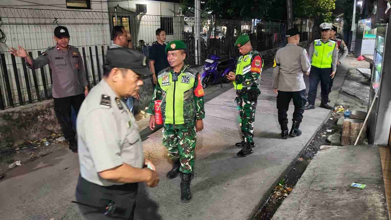 Anggota Babinsa Koramil Bantar Gebang dan personil Kepolisian berinteraksi serta patroli malam bersama warga di Kota Bekasi.