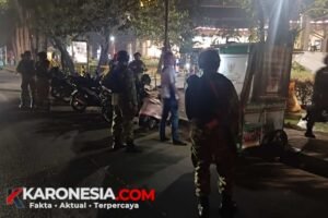 Personel Babinsa dan Komduk berseragam loreng berjaga di tepi jalan saat patroli malam di Tangerang