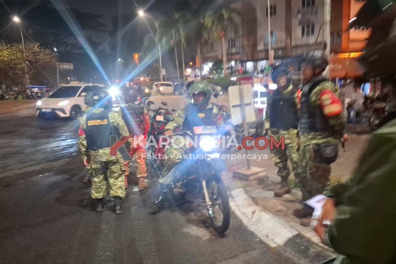 Personel Babinsa berseragam loreng dan rompi, sebagian bersepeda motor, berjaga di jalan saat patroli malam bersama warga