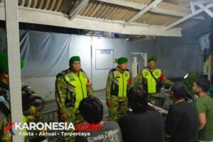 Tiga personel Koramil 04/Jati Asih berompi reflektif berbincang dengan warga saat patroli malam di Jati Asih, Kota Bekasi