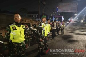 Aparat gabungan TNI dan Polri mengenakan rompi keselamatan hijau neon bersiaga di pinggir jalan raya rawan kriminalitas di Bekasi saat menggelar patroli malam preventif.
