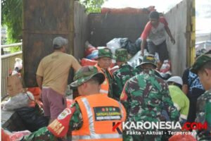 Anggota TNI Kodim 0506 Tangerang bersama warga mengangkut tumpukan sampah ke dalam truk di Pasar Ciputat