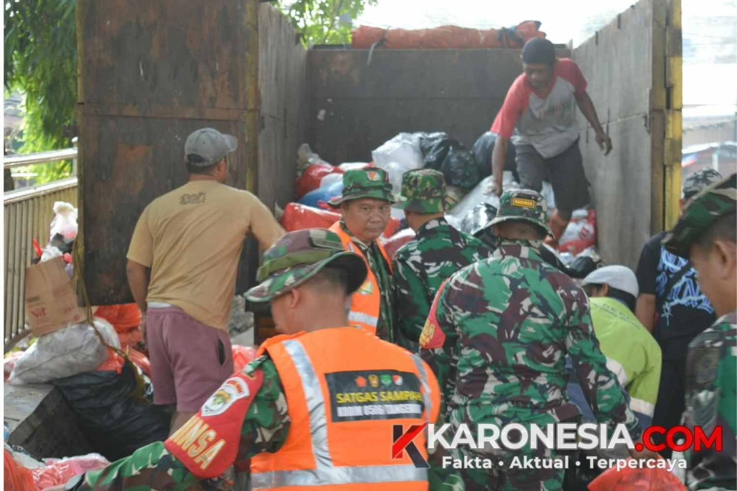 Anggota TNI Kodim 0506 Tangerang bersama warga mengangkut tumpukan sampah ke dalam truk di Pasar Ciputat