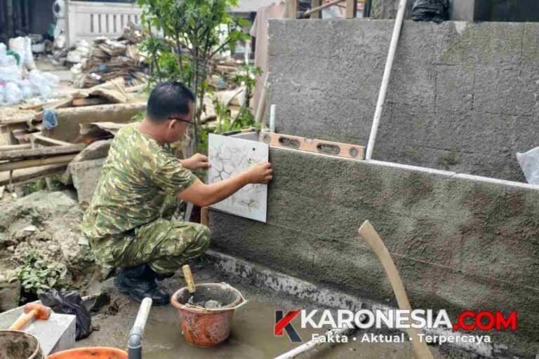 Anggota Satgas TMMD Tigaraksa memasang keramik dinding fasilitas air bersih di Jayanti Tangerang