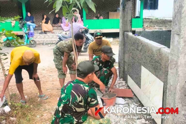Prajurit TNI dan warga bergotong royong memasang keramik tandon air bersih di Kampung Kramat