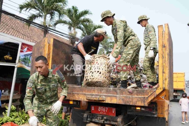 Personel TNI Kodim 0510 Tigaraksa bersama warga menaikkan keranjang sampah ke atas truk saat karya bakti di Pasar Gembong Balaraja Tangerang.